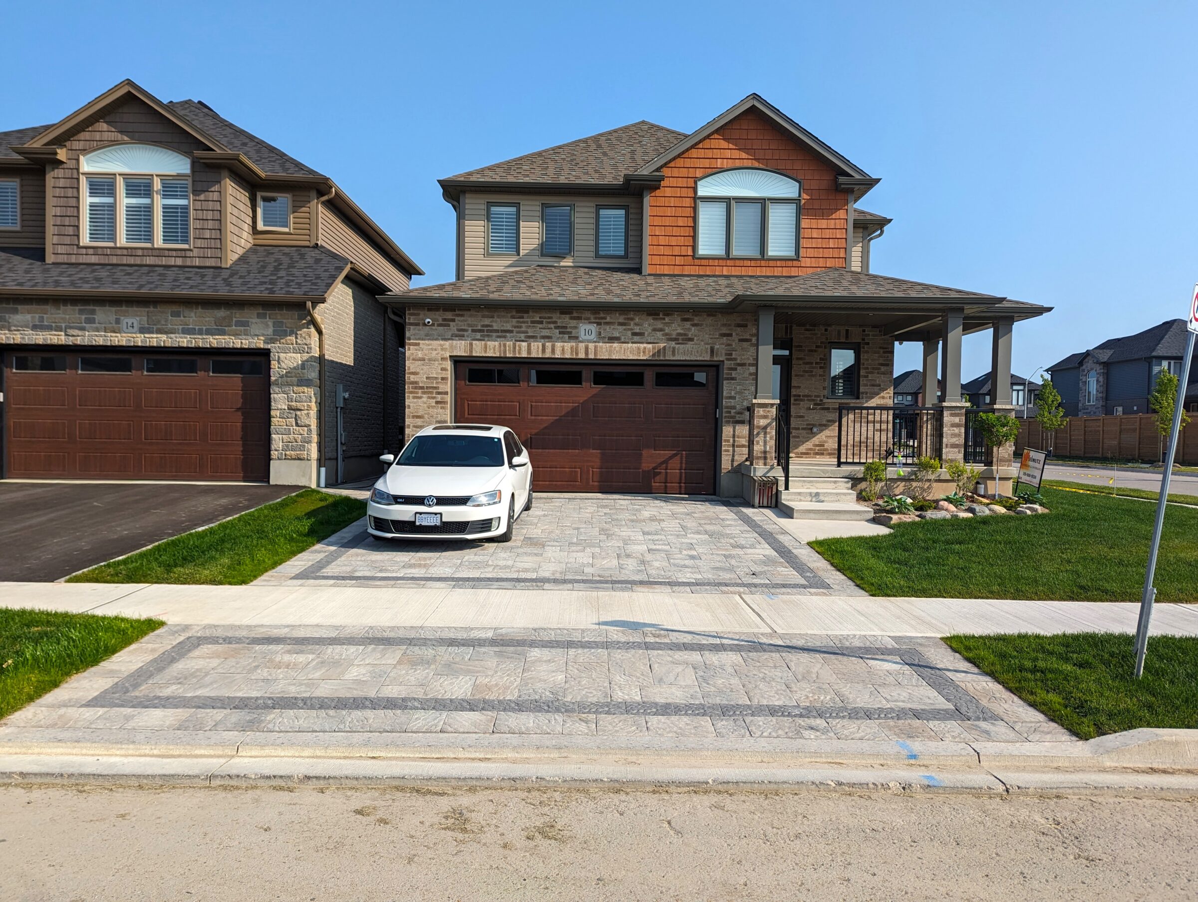 Interlocking driveway with a white care parked.