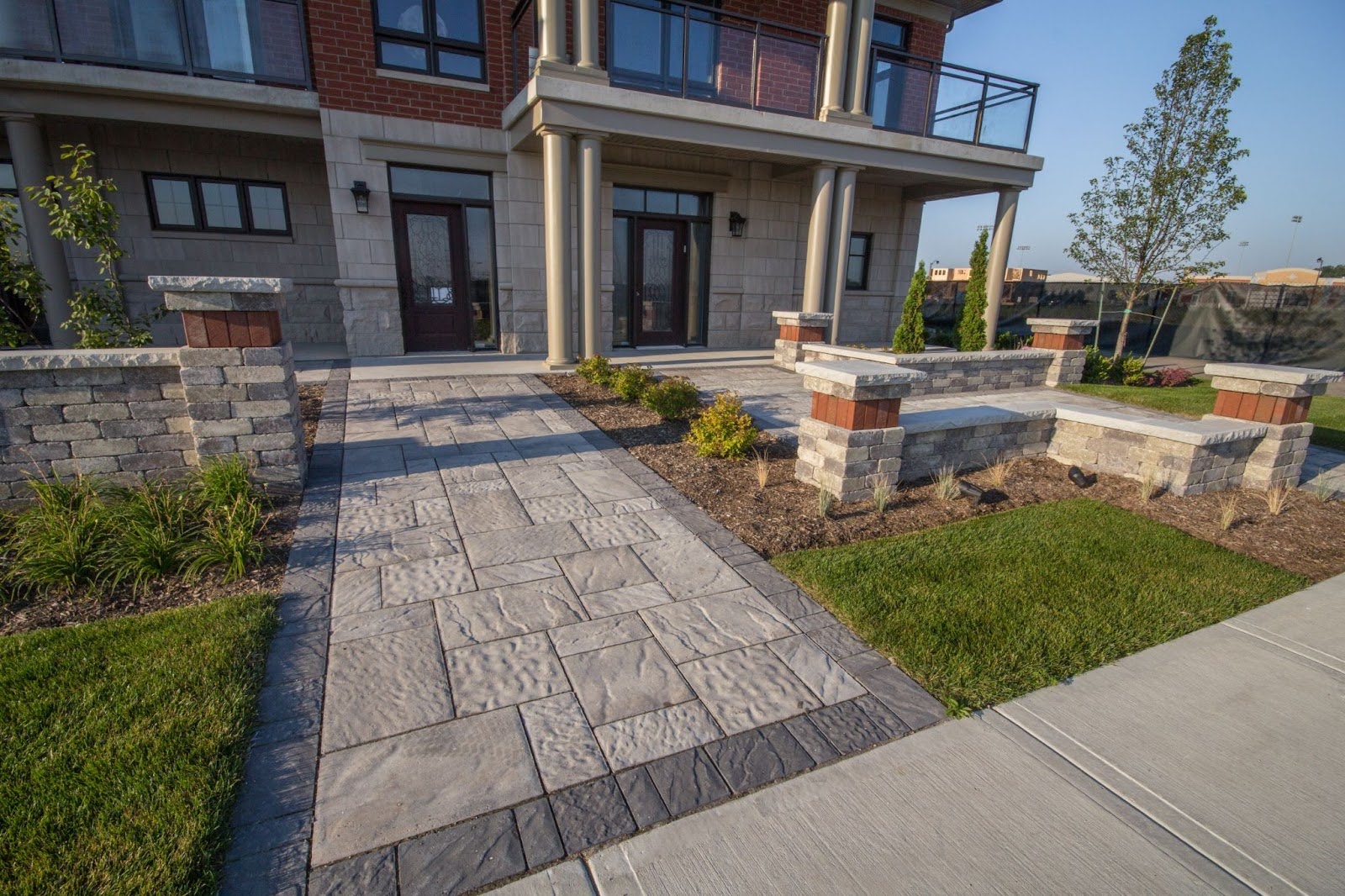 Small stone patio with wooden chair and garden plants.