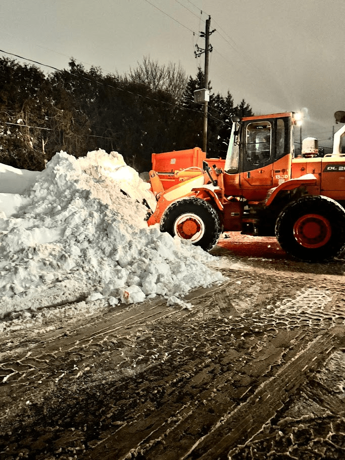 A tractor clearing snow on a commercial property