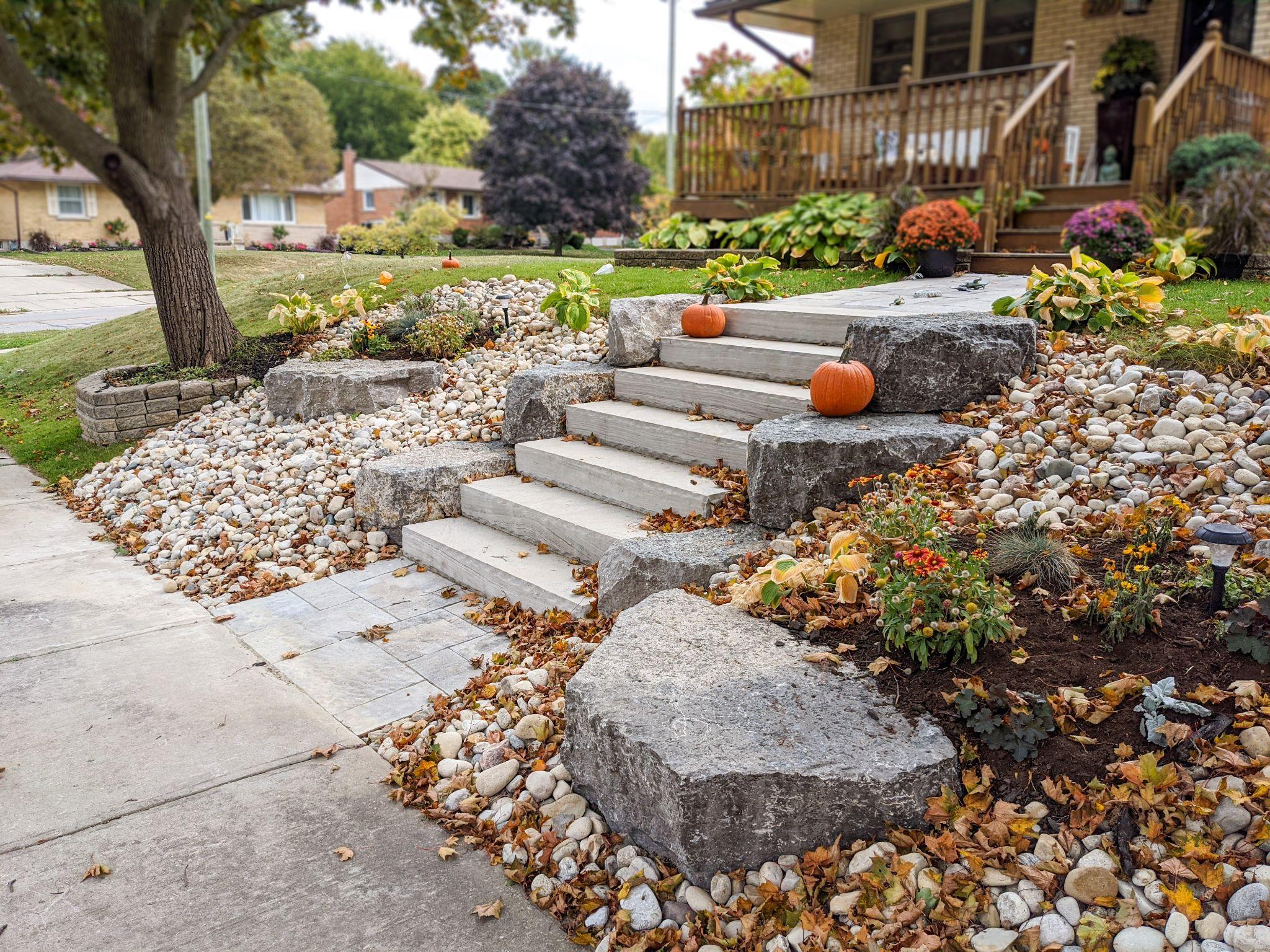 Armour stone front steps with river rock landscaping